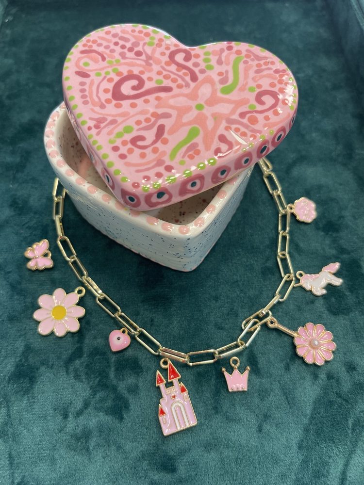 Charm bracelet beside a painted jewelry box