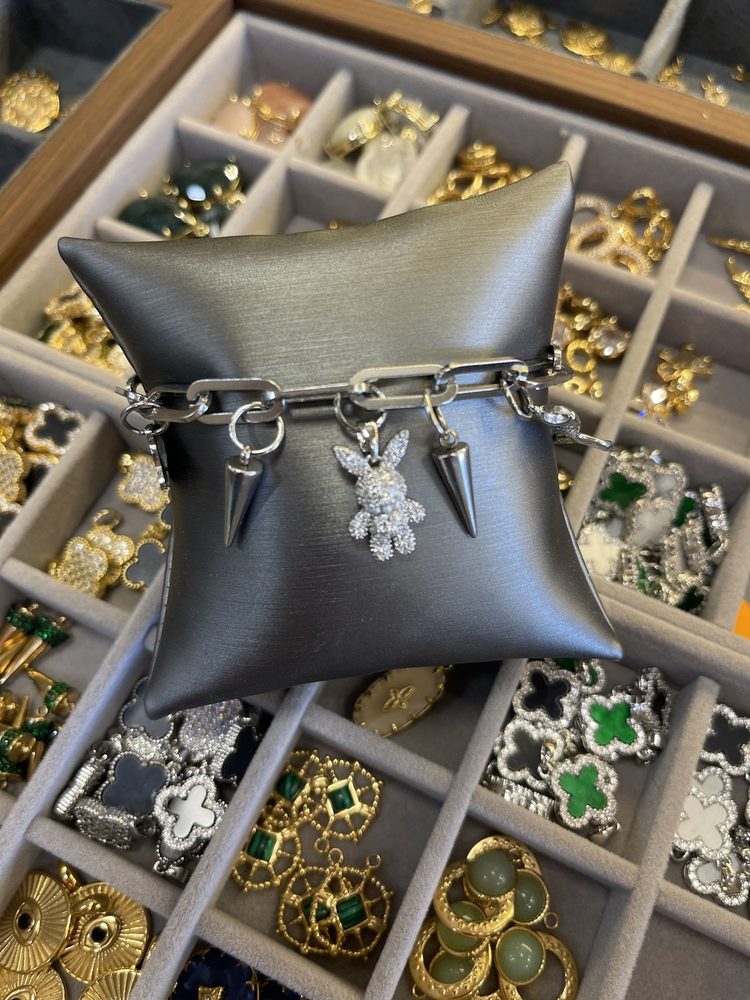 Silver charm bracelet on a display pillow